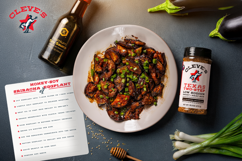 Plate of Cleve's honey-soy sriracha eggplant topped with green onions, beside soy sauce, honey, and a bottle of Texas Two-Step seasoning.