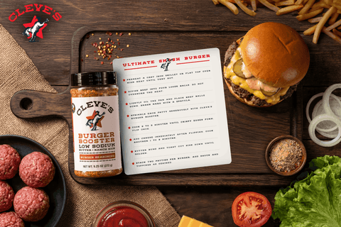 Cleve's ultimate smash burger with melted cheese and pickles, served with fries, beside raw beef and a bottle of Burger Booster seasoning.