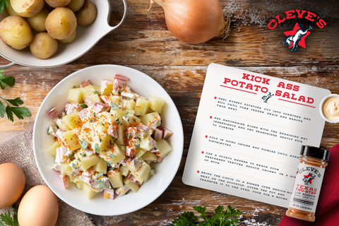 Bowl of Cleve's potato salad with red onion, parsley, and paprika, beside baby potatoes, eggs, and a bottle of Texas Two-Step seasoning